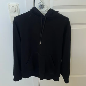 Svart hoodie från H&M XS - En klassisk svart hoodie från H&M i storlek XS. Tröjan har huva med snörning och en stor känguruficka framtill. Bara använd några gånger. 
