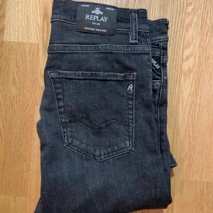 Svarta Replay jeans straight fit - Snygga svarta jeans från Replay med klassisk femficksdesign och diskret Replay-logga på fickan. Jeansen har rak passform och är tillverkade i mjukt jeanstyg som sitter skönt hela dagen. Perfekta för dig som gillar stilrena och tidlösa jeans. Jeansen passar även mig som är 180 cm! Bara att skriva om du har någon fundering.