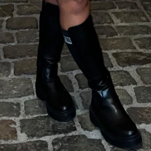 Svarta MTNG höga boots  - Säljer dessa boots frän MTNG i storlek 37 men passar mig som har 38 sả de är lite stora i storlek. Använda endast 1 gảng sả de är i mycket bra skick.