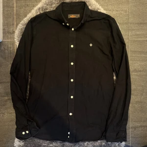 Morris Skjorta Svart - Klassisk svart skjorta från Morris. Perfekt både till vardags och mer dressade tillfällen. Enkel att kombinera och en tidlös del i garderoben.