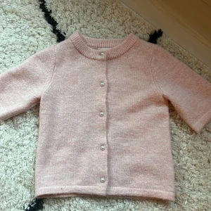 Ljusrosa stickad T-shirt kofta från Gina Tricot💓 - Supersöt ljusrosa kofta från Gina Tricot med korta ärmar och pärlknappar framtill. Koftan är stickad och i fint skick! 💕
