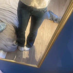 Mörkblå bootcut jeans med kontrastsömmar - Säljer ett par mörkblå jeans med bootcut-modell och snygga kontrastsömmar. Jeansen har klassisk femficksdesign och låg midja. Materialet är klassisk denim som sitter skönt hela dagen. Storlek 34/S