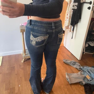 Blå bootcut jeans med broderade fickor - Lågmidjade jeans från Gina Tricot, knappt använda då dom är för små