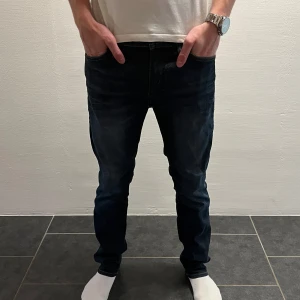 Mörkblå slim fit  jeans från Jack & Jones - Snygga mörkblå jeans från Jack & Jones (L32 och W29). Modellen har slim fit passform och är tillverkad i slitstarkt bomullsmaterial. Perfekt för dig som gillar en enkel och stilren look med jeans som funkar till det mesta.