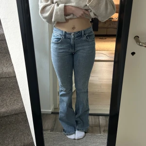 Ljusblå lågmidjade bootcut jeans - Säljer ett par ljusblå jeans med bootcut-modell. Jeansen har klassisk femficksdesign, normal passform och är tillverkade i mjukt denimtyg. Perfekta för dig som gillar en avslappnad men ändå trendig look. Säljer då de är för stora 🩷