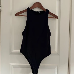 Svart bodysuit från Zara - En svart, ärmlös bodysuit från Zara med rund halsringning och tight passform. Tillverkad i mjukt och stretchigt material som sitter snyggt på kroppen. Passar även S 🖤