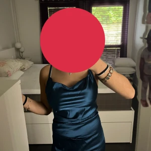 Mörkblå långklänning - Säljer en elegant mörkblå långklänning i glansigt material med smala axelband. Har aldrig använts, ser helt ny ut.💙💙💙