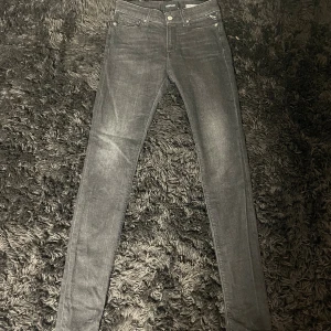 Replay Luzien skinny jeans svart - Storlek: W28 L32.  Svarta skinny jeans från Replay, modell Luzien. Hög midja och klassisk femficksdesign med Replay-logga på fickan. Jeansen är i stretchigt denim och har en snygg, mörk tvätt som passar till allt. Perfekta för dig som gillar en tight och modern look. 
