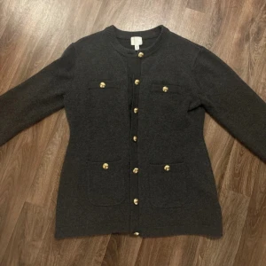 Mörkgrå kofta från H&M med guldknappar - Snygg mörkgrå kofta/cardigan från H&M, storlek L
