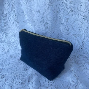 Mörkblå jeans necessär/väska - Mörkblå jeanstvätt med guldig dragkedja✨💙Mått: 16x12x7cm.                                                  Produkten är av helt återanvänd textil, för miljöns skull♻️                                                       Pris: 179kr +frakt