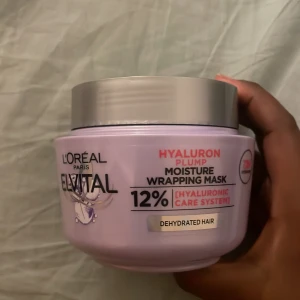 L'Oréal Elvital Hyaluron Plump Mask - Fuktboostande hårmask från L'Oréal Elvital Hyaluron Plump-serien. Kommer i en ljuslila burk med grått lock och innehåller en krämig, lila gel-formula. Perfekt för torrt hår som behöver extra återfuktning med hyaluronsyra.