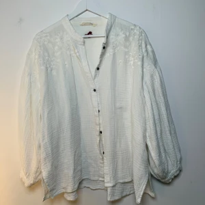 Odd Molly vit blus  - Vit blus med broderade detaljer på axlarna och ryggen. Blusen har en avslappnad passform och knäpps med knappar framtill. Perfekt för en ledig men stilfull look. Storlek 2 (S-M) men mer en M/L skulle jag säga. 