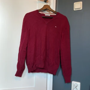J. Lindeberg tröja - En jättefin J. Lindeberg tröja i vinröd i 100% merino ull. Har tyvärr tvättas om sitter därför som medium nu. Några små defekter som knappast syns om man inte vet att de är där. 