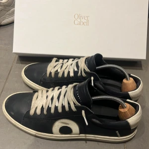 Oliver Cabell Low 1 Oxford sneakers - Säljer ett par feta Oliver Cabell Low 1 sneakers i Oxford-färg. PRISET ÄR EJ HUGGET I STEN! inga defekter på skorna men man kan se att de är lite använda. Du får med box som dock har en fläck där jag spillde cola😬men annars är det inget fel med dom. Perfekt för dig som vill ha ett par stilrena skor som passar till alla olika tillfällen! Runt 3000 nypris men vårt pris är 1099!