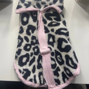 Leopardmönstrad fleece tröja med rosa kant - Säljer en fluffig teddyjacka med svartvitt storlek 20 leopardmönster och ljusrosa kantband. Jag har sytt den själv vilket syns men är av en gammal fleece så ordentlig material och perfekt när de är lit kyligt ute. 