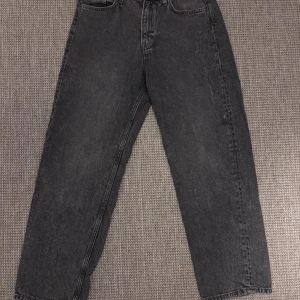 Grå loose fit jeans från H&M - Säljer ett par grå jeans från H&M i loose fit-modell med justerbar midja. Jeansen har klassisk femficksdesign och raka ben. Jeansen har används mycket bra.