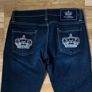 Mörkblå jeans Victoria Beckham - Snygga mörkblå jeans från Victoria Beckham med raka ben och vita kontrastsömmar. Bakfickorna har broderade kronor i silvertråd som ger en lyxig känsla. Klassisk femficksmodell i stretchig denim som sitter skönt och stilrent. Pris kan diskuteras. Har aldrig fått så många komplimanger för ett par jeans förut!