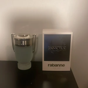  Paco Rabanne parfym - Köpte helt ny använd ungefär två gånger Parfymflaska i unik design med metallock och frostat glas. På locket står det 'Invictus'. Perfekt för dig som vill sticka ut med en ikonisk accessoar på hyllan.100 ml 
