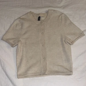Beige stickad kofta med kort ärm - Mjuk och inte alls stickig och aldrig använt.