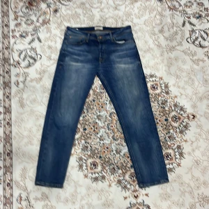 Blå jeans med raka ben - Snygga blå jeans med klassisk tvätt och raka ben. Jeansen har fem fickor och normal passform, perfekta för en avslappnad stil. Tillverkade i slitstarkt denimtyg som ger en tidlös look.