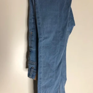Blåa wide jeans med slits - Snygga blå jeans med breda ben och slits nertill. Jeansen har klassisk denimlook och är perfekta för dig som gillar en avslappnad och trendig stil. Passar till sneakers eller boots för en cool vibe.