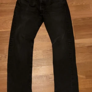 Svarta Levi's 501 jeans W31 L32 - Svarta Levi's 501 jeans med klassisk rak passform och femficksdesign. Jeansen har en snygg mörk tvätt och är tillverkade i slitstarkt denim. Perfekta för dig som gillar en tidlös och clean look.