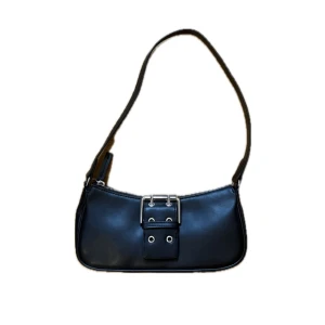 Svart axelväska med spänne - Stilren svart axelväska i skinn med silverfärgat spänne och detaljer framtill.