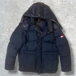Tommy Hilfiger jacka - Säljer denna marinblåa dunjackan från Tommy Hilfiger. Jackan kommer i stl S men passar som M också och den har inga tecken på slitage. Här av er vid intresse, pris kan diskuteras vid snabb affär!