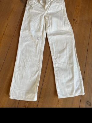 Vita jeansbyxor från 157 Boulevard S - Snygga vita jeansbyxor från 157 Boulevard i storlek S. Modellen har raka ben och fransade benslut för en cool och avslappnad vibe. Klassisk femficksdesign och tillverkade i mjukt bomullstyg. Perfekt för dig som gillar streetstyle och vill sticka ut.