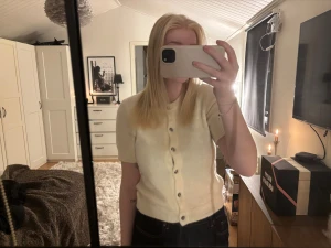 Vit stickad tröja med knappar från Gina Tricot - Superfin ljus kofta från Gina Tricot med korta ärmar och rund hals. Den har silvriga knappar framtill och är stickad i ett mjukt material som känns fluffigt🤍