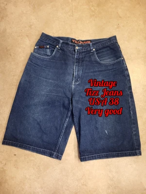Vintage y2k Tizz Jean shorts - USA size 38!!!!!!! Check size chart before purchasing!  These stylish streetwear shorts are perfect for the resurgence of y2k fashion. They have a baggy design, large pockets, a rip detailing on the front, and embroidered back pocket. Very sturdy, good quality. Has one very minor imperfection on the back waste that is only noticeable upon very close inspection. Otherwise in great shape.