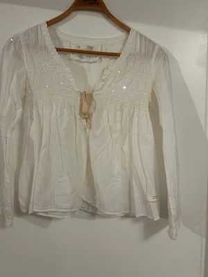 Blus odd Molly  - Fin långärmad blus från odd Molly med knytning och lite paljetterliknande fram till. Storlek 0 motsvarar xs