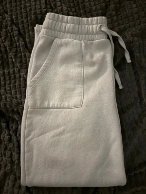 Vita mjukisbyxor Lager 157 - Säljer ett par vita mjukisbyxor i storlek M men passar mig som har XS och inte för långa jag är 156cm. med elastisk midja och snörning. Byxorna har fickor fram och bak, samt är tillverkade i mjukt bomullsmaterial. Perfekta för chill dagar och har en relaxed passform.