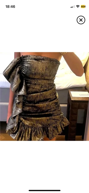 Glittrig guld kortklänning med volang - SÖKER denna guldklänning från zara i storlek xs eller s. Den har fina volangdetaljer och är one shoulder. Klänningen är axelbandslös och har en tight passform som framhäver figuren. Perfekt för dig som vill sticka ut och glänsa på festen.