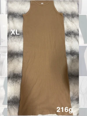 Brun ärmlös långklänning lager 157 XL - En stilren brun långklänning från lager 157 i storlek XL. Klänningen är ärmlös med rund halsringning och har en rak, enkel passform. Perfekt för dig som gillar minimalistisk och clean stil.🌸Sparsamt använd. Storlek XL