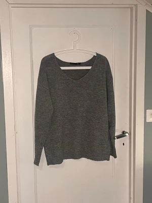 Grå stickad tröja med v-ringning XS - Mysig grå stickad tröja från lager 157 i storlek XS. Tröjan har en snygg v-ringad hals och långa ärmar, perfekt för lager på lager. Enkel och stilren design som funkar till jeans eller kjol. Skulle säga att den är i bra skick, det enda är att tyget är lite nopprigt men det är inget stort problem enligt mig😊