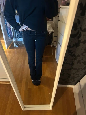 Svarta bootcut jeans  - Säljer ett par svarta Zara jeans med bootcut passform och klassisk femficksdesign. Jeansen har låg midja och är tillverkade i mjukt jeansmaterial med stretch. Snygga att styla med sneakers eller boots. Passar dig som gillar en tidlös look. Lite slitna längst ner men inget som märks! Jag är 172! 82 innebenslängd