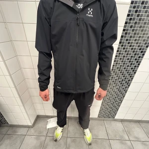 Svart vindjacka från Haglöfs - Helt ny svart haglöfs jacka. Säljer denna jacka pågrund av att den är för stor för mig annars är den jätte skön att ha.
