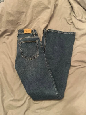 Mörkblåa bootcut jeans från Gina  - Mörkblåa lågmidjade bootcut jeans från Gina. Oanvända