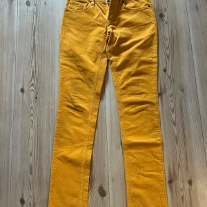 Gula manchesterbyxor från Gant 28/34 - Snygga gula manchesterbyxor från Gant med låg midja och regular fit. Byxorna har klassisk femficksdesign och raka ben. Perfekta för dig som vill sticka ut med färg och gillar retrovibbar. Materialet är mjukt och skönt manchester.