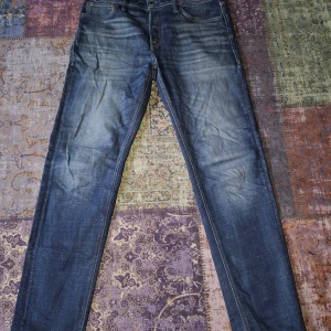 Jack & Jones jeans  - Snygga blåa jeans från Jack & Jones i gott skick. Det är en rak till smalare passform, på byxan står det Tapered/Mike. Säljer för att dom är för små för mig. Fråga om det behövs!