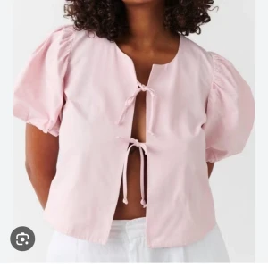 Ljusrosa blus med puffärm från Gina Tricot - Supersöt ljusrosa blus med korta puffärmar och två knytningar framtill. 