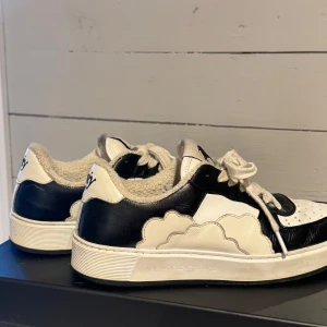  TWIY skor - Unika sneakers från TWIY i svart och vitt med coolt molndesign på sidorna, snörning och broderad logga bak. Dante Lindhe edition Följer med en tygpåse och kartong. Säljes på grund av att dem är lite för stora.  Använd fåtal gånger. Inköpspris 2399kr  Passar både tjej och kille Skriv för mer bilder eller info 
