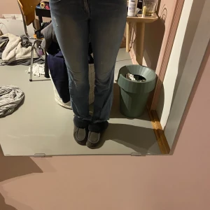 Ljusblå bootcut jeans med rå kant - Säljer ett par ljusblå jeans med bootcut passform och rå, fransig kant nertill. Jeansen har klassisk femficksdesign och är tillverkade i mjukt denimtyg. Perfekta för dig som gillar en avslappnad och trendig look. Jag har sytt om dom från skinny till bootcut och sprätt upp dom längst ner. Är 175 och dom är för korta på mig. En fläck på baksidan men inget man tänker på. 