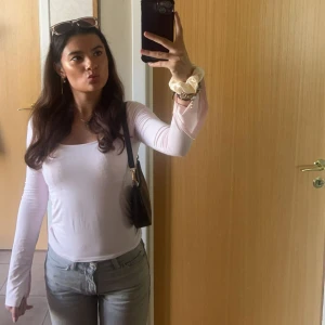 Ljusrosa långärmad topp - Säljer en ljusrosa långärmad topp med rundad, något fyrkantig urringning. Tunn och stretchig, perfekt för lager-på-lager eller som den är. Enkel och stilren design som passar till jeans eller kjol.