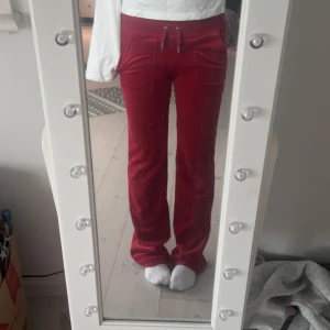 Röda velourbyxor Juicy Couture XS - Snygga röda velourbyxor från Juicy Couture i storlek xs, bara att skriva om man har nån fråga💕nypris runt 1300  och inte använda mycket alls!