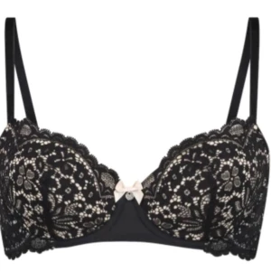Svart spetsbh från Hunkemöller - Supersnygg svart bh från Hunkemöller med blommig spets och ljus rosett framtill. Axelbanden är justerbara och kuporna har vacker spetsdetalj. Perfekt för dig som vill ha något extra under outfiten. Kostar ca 500 orginalt säljer pågrund av den va för liten 