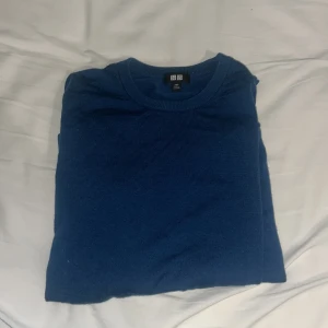 Blå stickad tröja från Uniqlo XXS - En klassisk blå stickad tröja från Uniqlo i storlek XXS. Tröjan har rund halsringning och långa ärmar, perfekt för lager-på-lager. Enkel och stilren design som funkar till det mesta. Materialet är merinoull och känns mjukt och bekvämt mot huden. Storleken är Xxs och passar nån runt 150-160 men kan passa större men då sitter den kortare nypris var 500 men jag säljer för billigare skriv om ni undrar något mvh Arvid