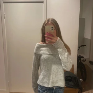 Ljusgrå offshoulder stickad tröja Kappahl - Superfin ljusgrå stickad tröja från Kappahl med offshoulder-modell. Tröjan är ribbstickad och har långa ärmar. Perfekt för dig som gillar en chill och trendig stil. Snygg att matcha med jeans eller kjol!