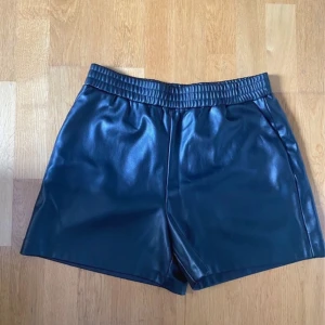 Svarta skinnshorts med resårmidja - Snygga svarta shorts i skinnimitation med elastisk resår i midjan. Köpte från Vinted men var dessvärre förstora. Hade prislappen på när jag köpte men klippte av då jag tvättade dem🎀